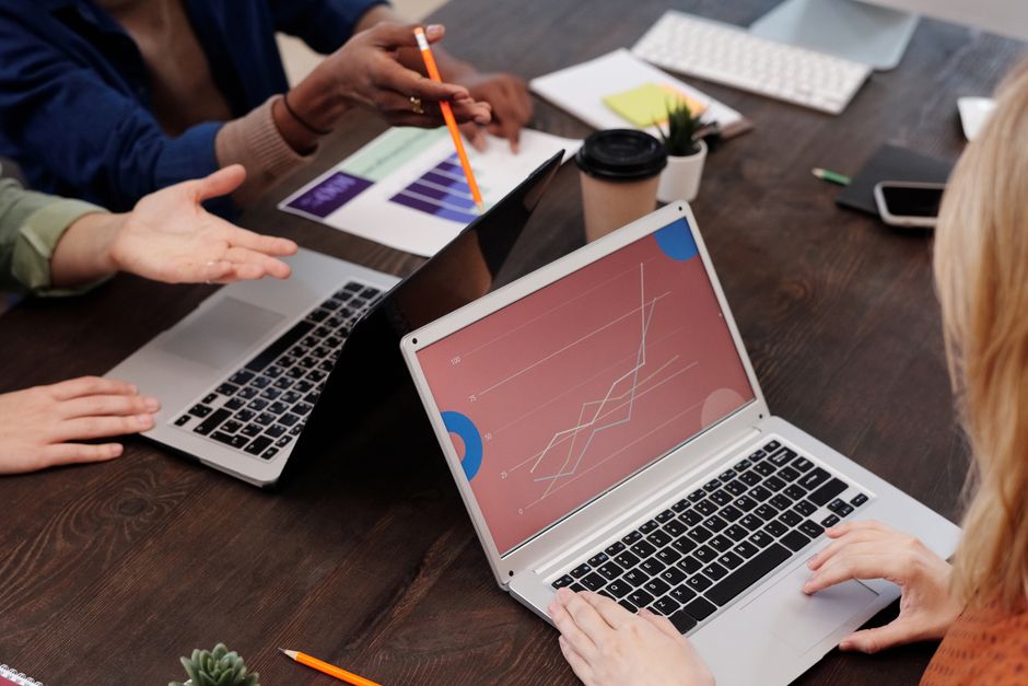 Business team discussing AI search results on laptop