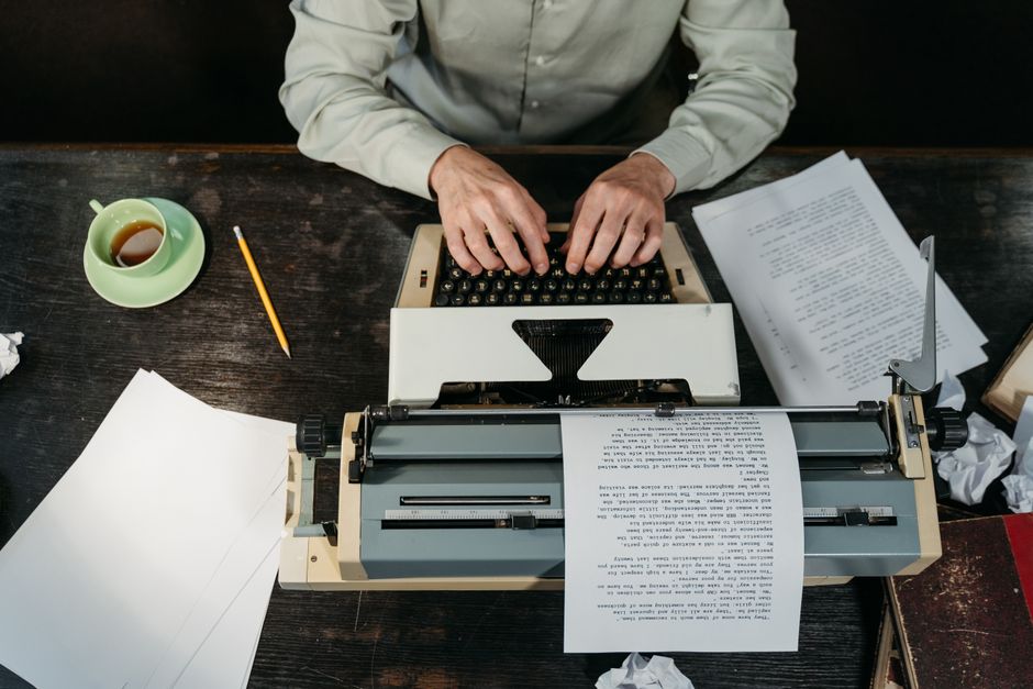 Writer cross-referencing sources at desk