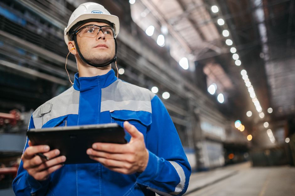 engineer inspecting industrial equipment with ultrasonic dev